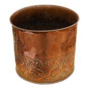 In the manner of John Pearson, an Arts and Crafts embossed copper log bin or planter, 27cm high