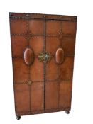 An early 20th century Spanish style studded, tan leather covered two door wardrobe, width 96cm,