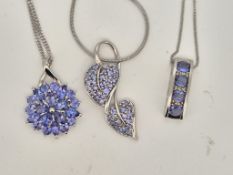 A modern 10k white metal, tanzanite and diamond chip cluster set line pendant, 17mm, on a white