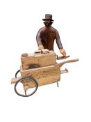 Pierre Decorse (b.1953), a carved wooden sculpture of a man playing the hurdy-gurdy