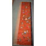 A LONG 19TH CENTURY CHINESE ORANGE RED SILK EMBROIDERED PANEL decorated with flowers. 190 cm x 57