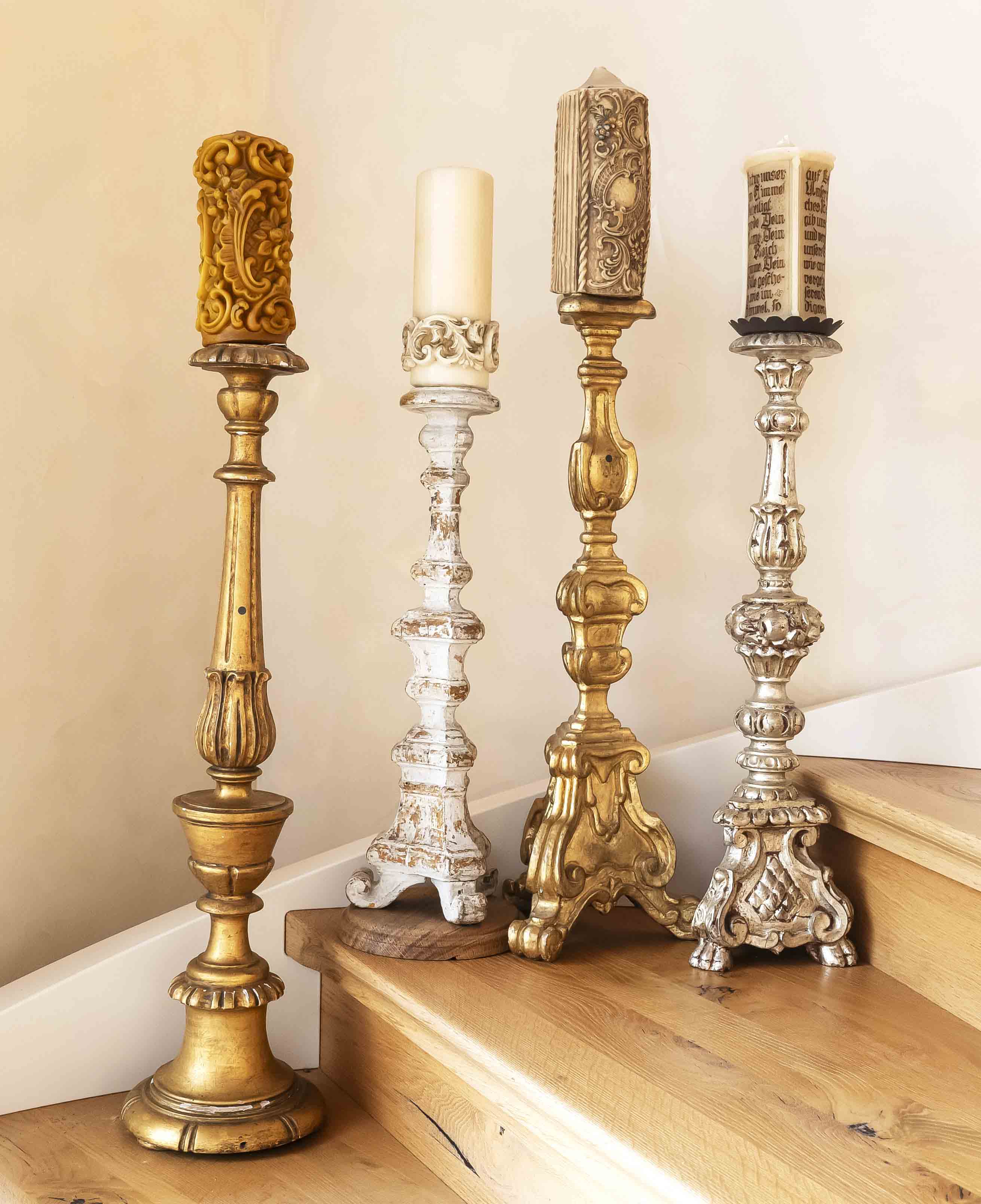 Four altar candlesticks, carved wood, one 18th century: painted white and gilded, rubbed, h. without