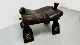 A CAMEL STOOL WITH LEATHER CUSHION.