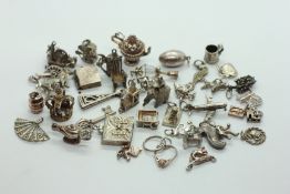 A GROUP OF APPROX 40 SILVER & WHITE METAL CHARMS.