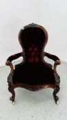 A VICTORIAN BUTTON BACK OPEN ARMCHAIR WITH CRIMSON VELOUR UPHOLSTERY.