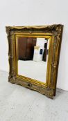 A HEAVY ORNATE GILT FRAMED MIRROR,