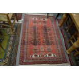 A Persian rug, red ground with stylised decoration, 180cm x 110cm.
