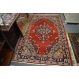 Persian rug, red ground with floral decoration, 215cm x 135cm.