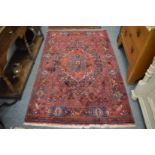 A Persian rug, red ground decorated with flowers, birds and animals, 210cm x 130cm.