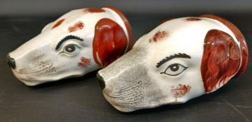 Two earthenware stirrup cups in the form of hounds heads, 11.5cm long