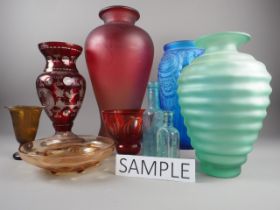 A red smoky glass baluster vase, 17 3/4” high, a red overlaid cut glass vase, 12” high, an amber