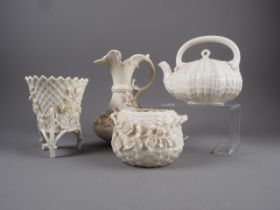 A Belleek floral encrusted china jug, a Belleek teapot with coral stick handle, a similar vase and a
