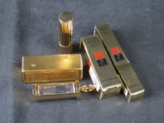 Estee Lauder lipstick and two Yves Saint Laurent items in original packaging.