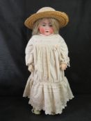 A Cuno & Otto Dressel bisque head doll having sleepy eyes, open mouth with teeth and rosy cheeks.