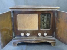 A mid century two door cabinet with a quarter veneered walnut top above a shaped front with egg and