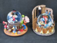 Two Disney Mickey Mouse snow globes.