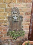 A cast iron lion heads wall fountain, 80 x 40cm.