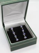 A pair of silver and purple stone earrings in presentation box.