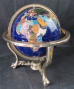 A vintage gemstone globe with compass below.