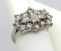 An 18ct white gold and diamond cluster ring, central stepped cut diamond measuring approx 5.4 x 3.