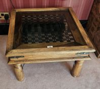A contemporary square shaped side table of Indo-Asian influence with smoked glass inset