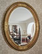 An attractive part gilded bevelled edge oval wall mirror measuring, 88 x 68cm.