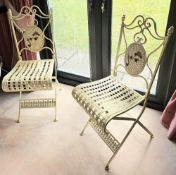 A pair of attractive folding metal bistro chairs.