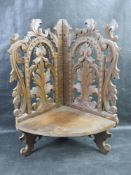 A black forest type carved wooden corner shelf having hinged shelf.