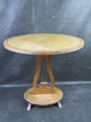 A leather topped wine table with lyre base.