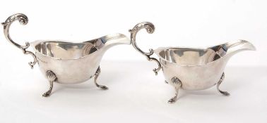 A pair of George V silver sauce boats of typical form, having wavey rims and flying leaf capped