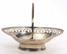 A George III silver swing handle basket of oval form with reeded rim and handle, the upper body