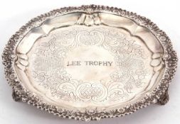 A George IV silver card salver of circular form with a cast applied edge, decorated with a floral