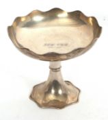 A George V silver pedestal bowl having wavy rims and a ring turned detail stem, the shallow bowl
