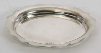 A hallmarked silver tray of plain oval form having a wavy rim, Sheffield 1963, makers mark E