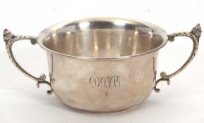 A George V twin handled silver bowl of plain compressed circular form, the handles with acorn
