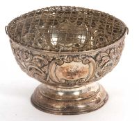An Edwardian silver rose bowl of circular form, embossed with foliate and C scroll decoration,