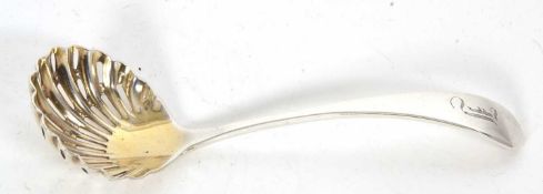 An Edwardian silver sifter spoon, the shell bowl with a cut work pattern and lightly gilded, the