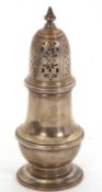 A George V silver caster of typical form, pull-off pierced cover having an urn finial, engraved with