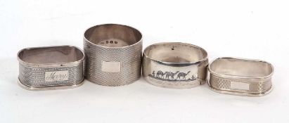 A group of three silver serviette rings, two oblong shaped and one circular, each with engine turned