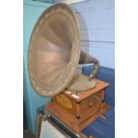 A model of a wind up gramophone with large metal horn, the wooden base with inlay of cherubs and