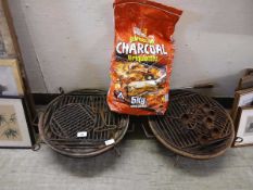 Two cast metal barbeques along with a bag of charcoal brickettes