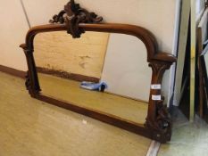 A carved mahogany framed over mantle mirror