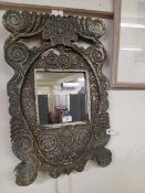 A carved wooden framed distressed wall mirror