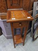 A wood and bamboo plant stand with drawer