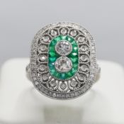 A PLATINUM EMERALD AND DIAMOND PANEL RING.