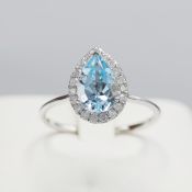 A 9CT WHITE GOLD TOPAZ AND DIAMOND CLUSTER RING.