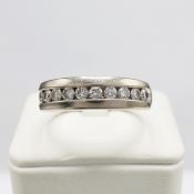 A 14CT WHITE GOLD DIAMOND SET HALF ETERNITY RING.