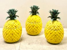 SET OF THREE CERAMIC PINEAPPLE JARS.