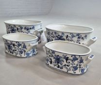 SET OF FOUR BLUE AND WHITE CERAMIC PLANTERS.