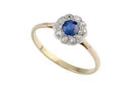 A sapphire and diamond cluster ring, the circular mixed-cut sapphire bordered by old and single-